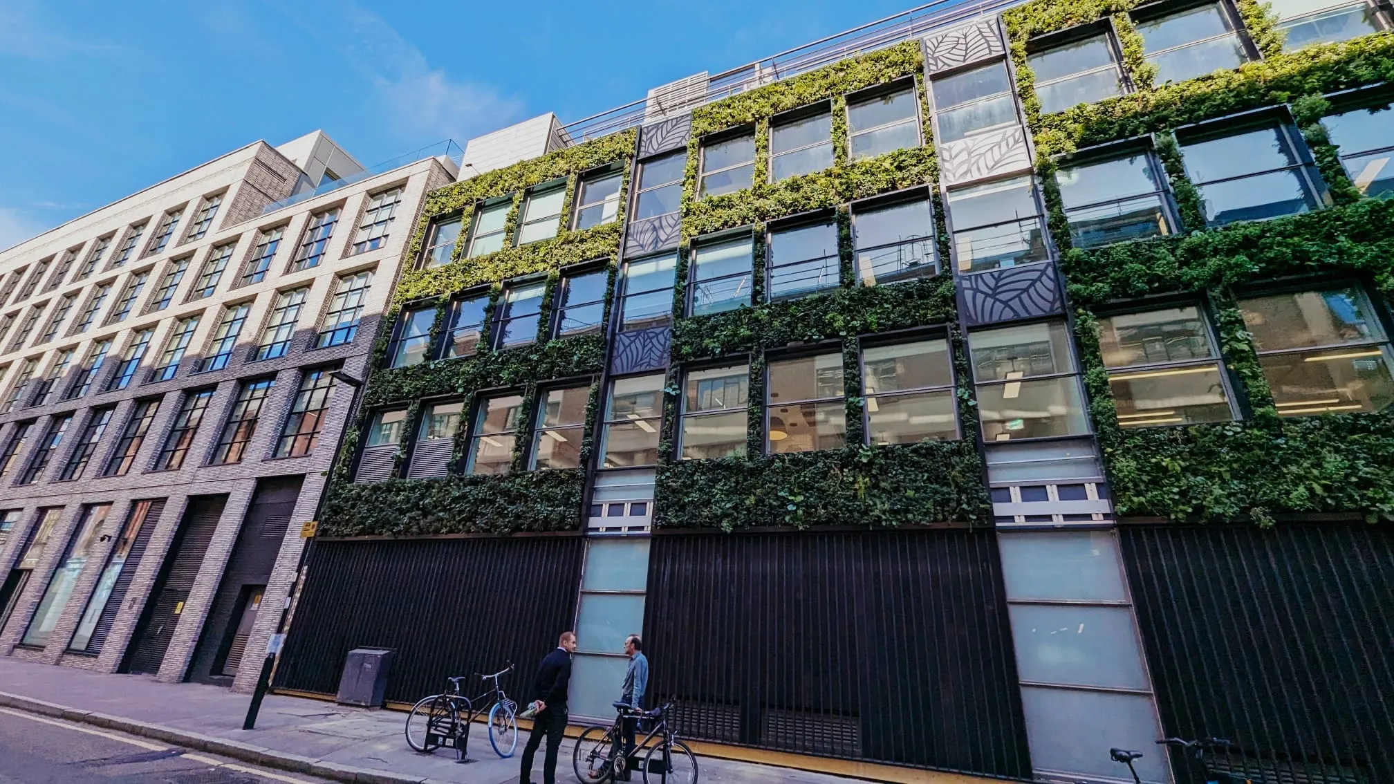Modern office buildings with green vertical gardens and bicycles