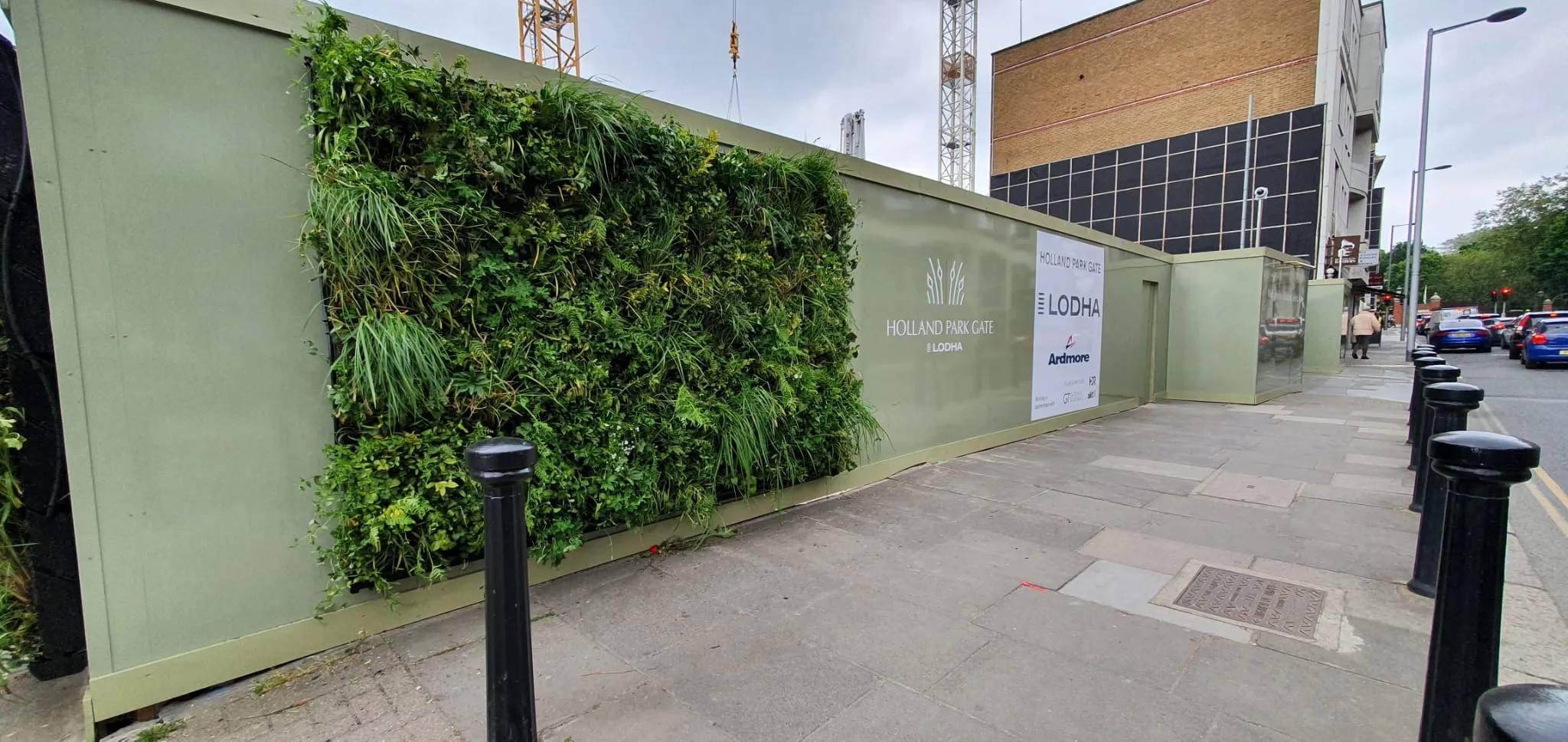 Green living wall at Holland Park Gate construction site with Lodha signage