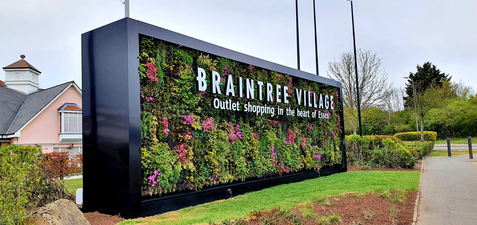 Braintree Village sign with lush vertical garden wall in Essex