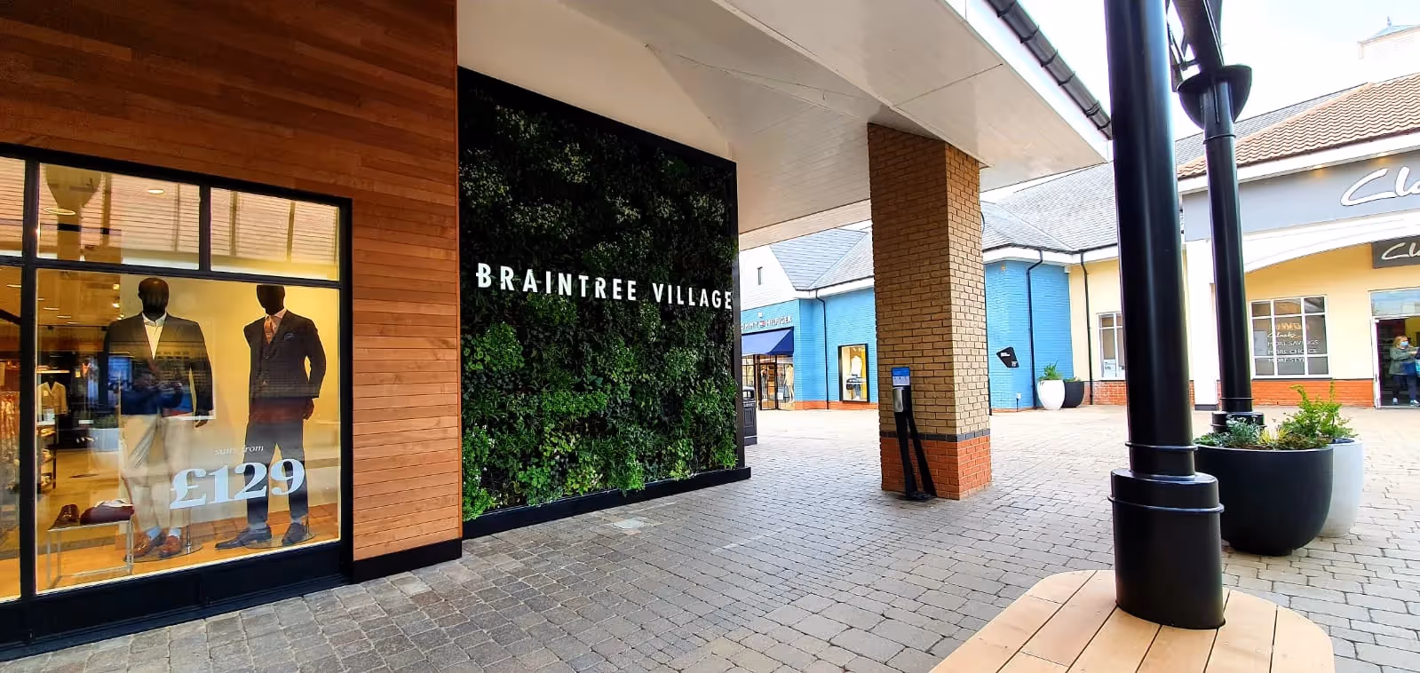 Braintree Village shopping center with mannequins and green wall signage