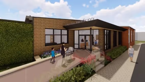 Modern school building exterior with landscaping and people walking outside