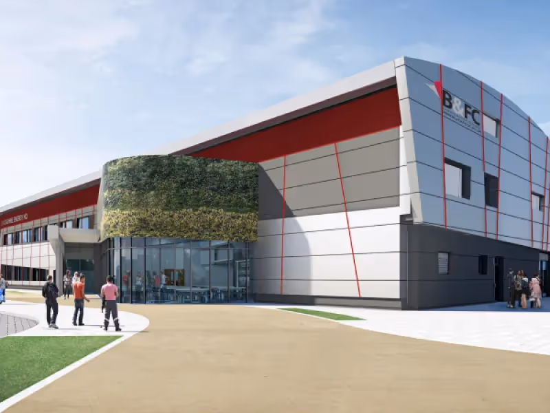 Modern BFCL building with green wall, people walking near entrance