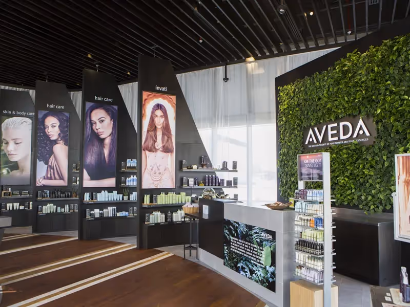 Aveda hair and skincare store interior with product displays and green wall