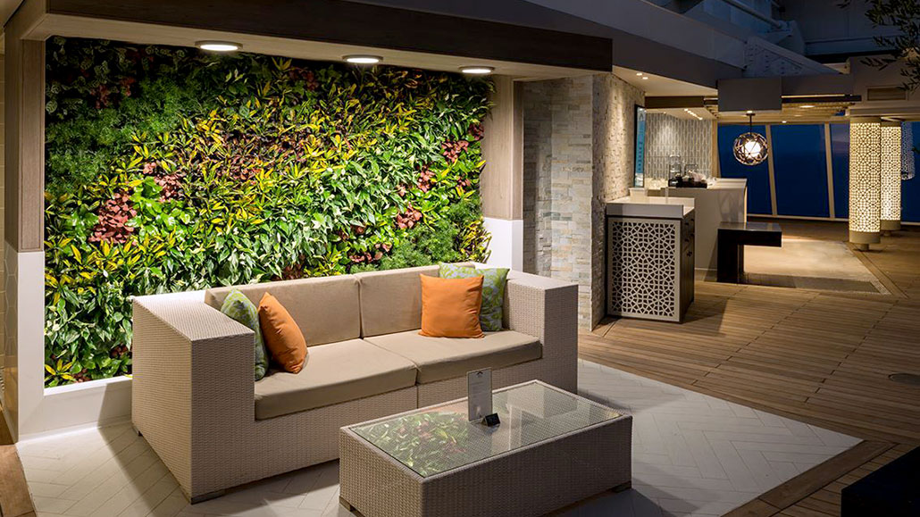 Modern lounge with living green wall, white sofa, and outdoor deck