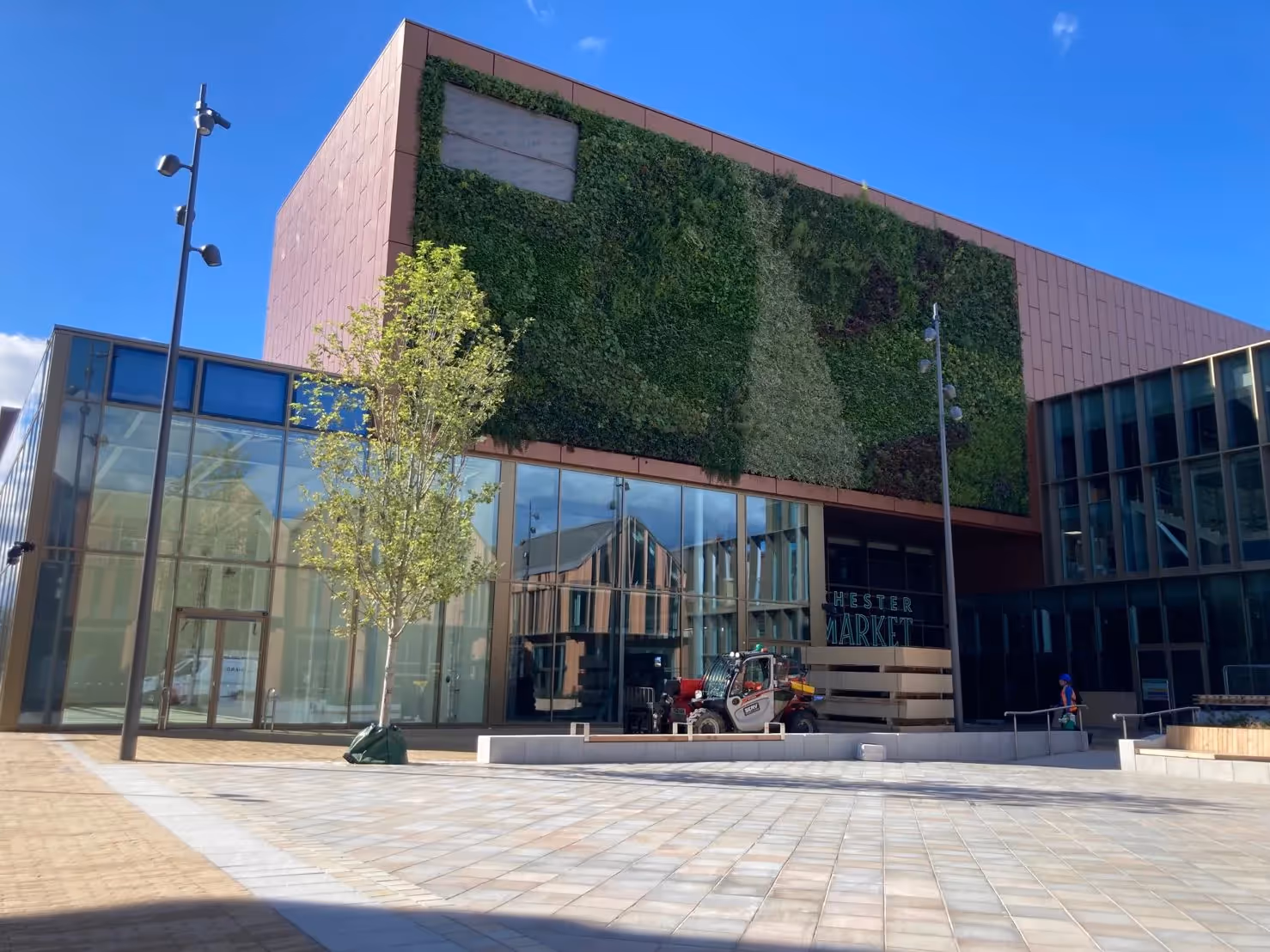Modern Chester Market building with green wall, glass facade, and forklift