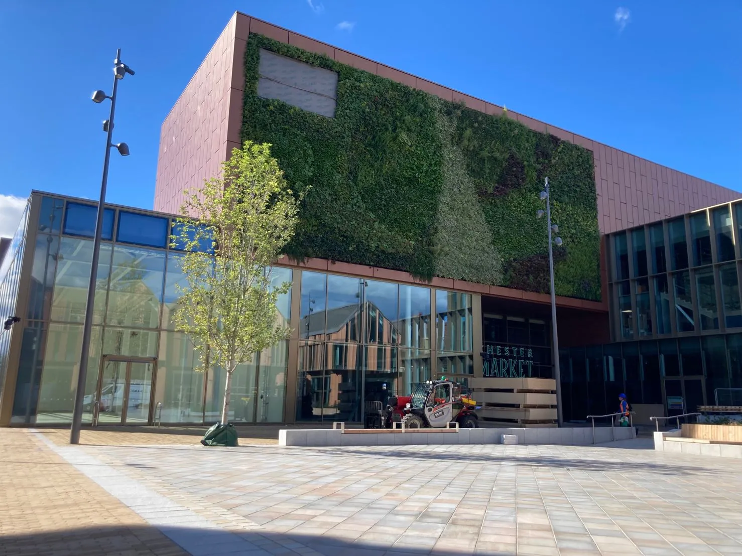 Modern Chester Market building with green wall, glass facade, and forklift