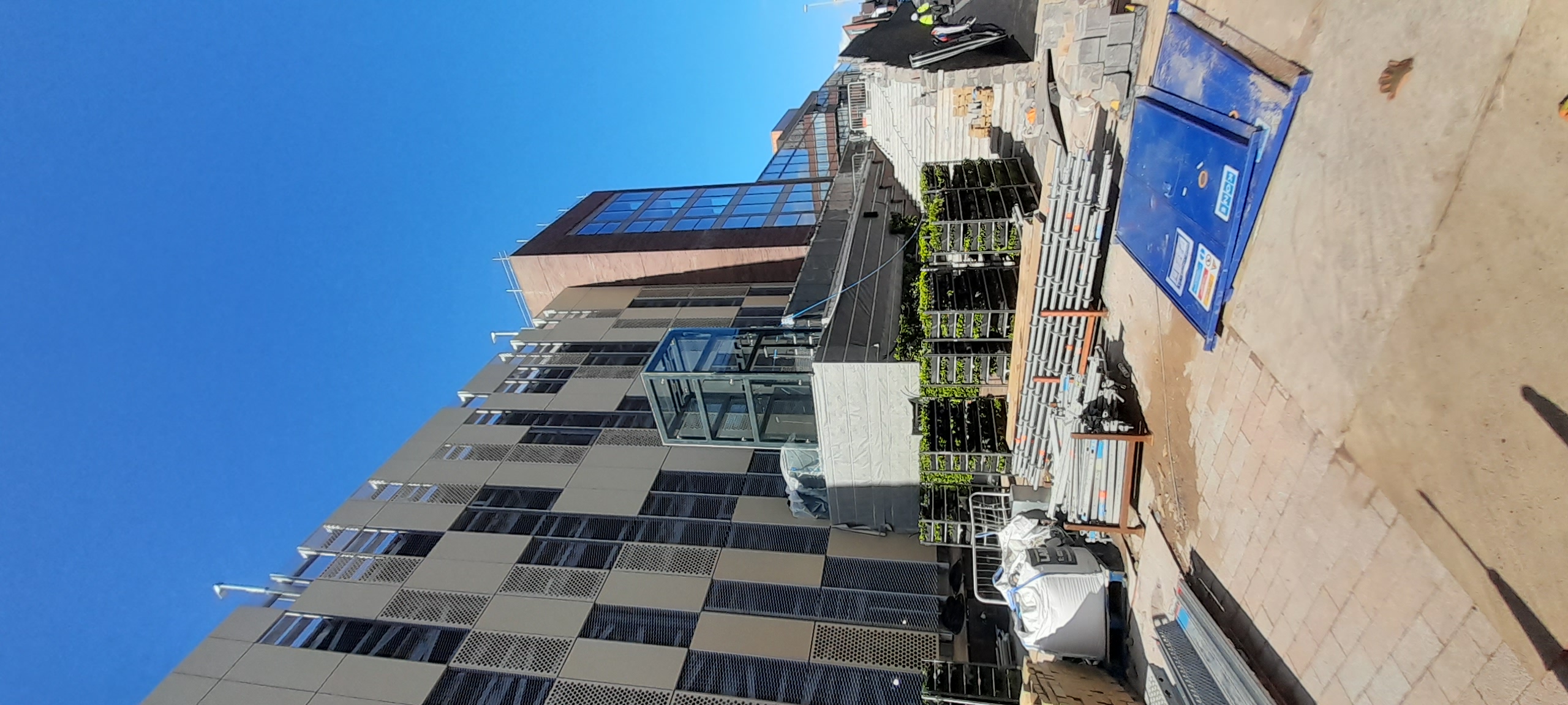 Modern building construction site with glass exterior and landscaping materials