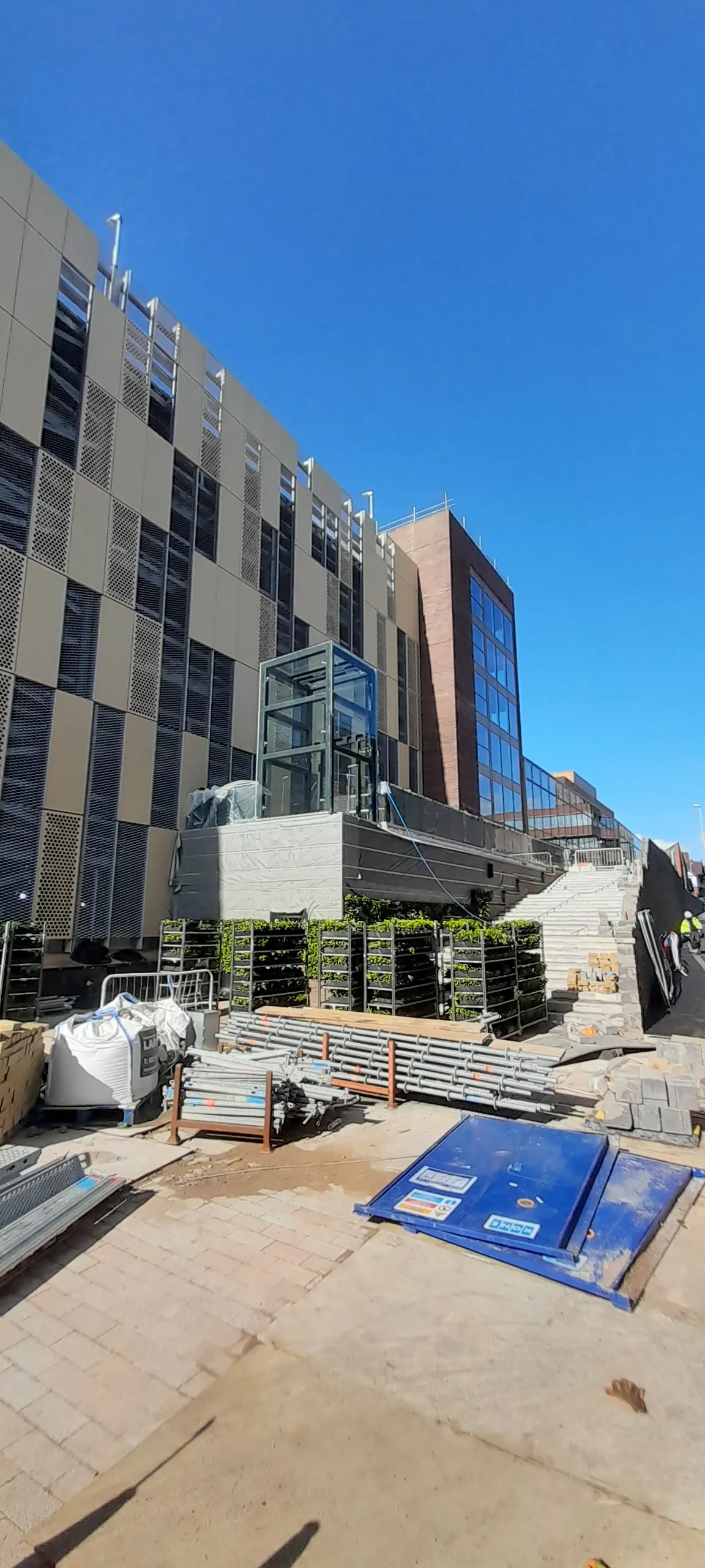 Modern building construction site with glass exterior and landscaping materials