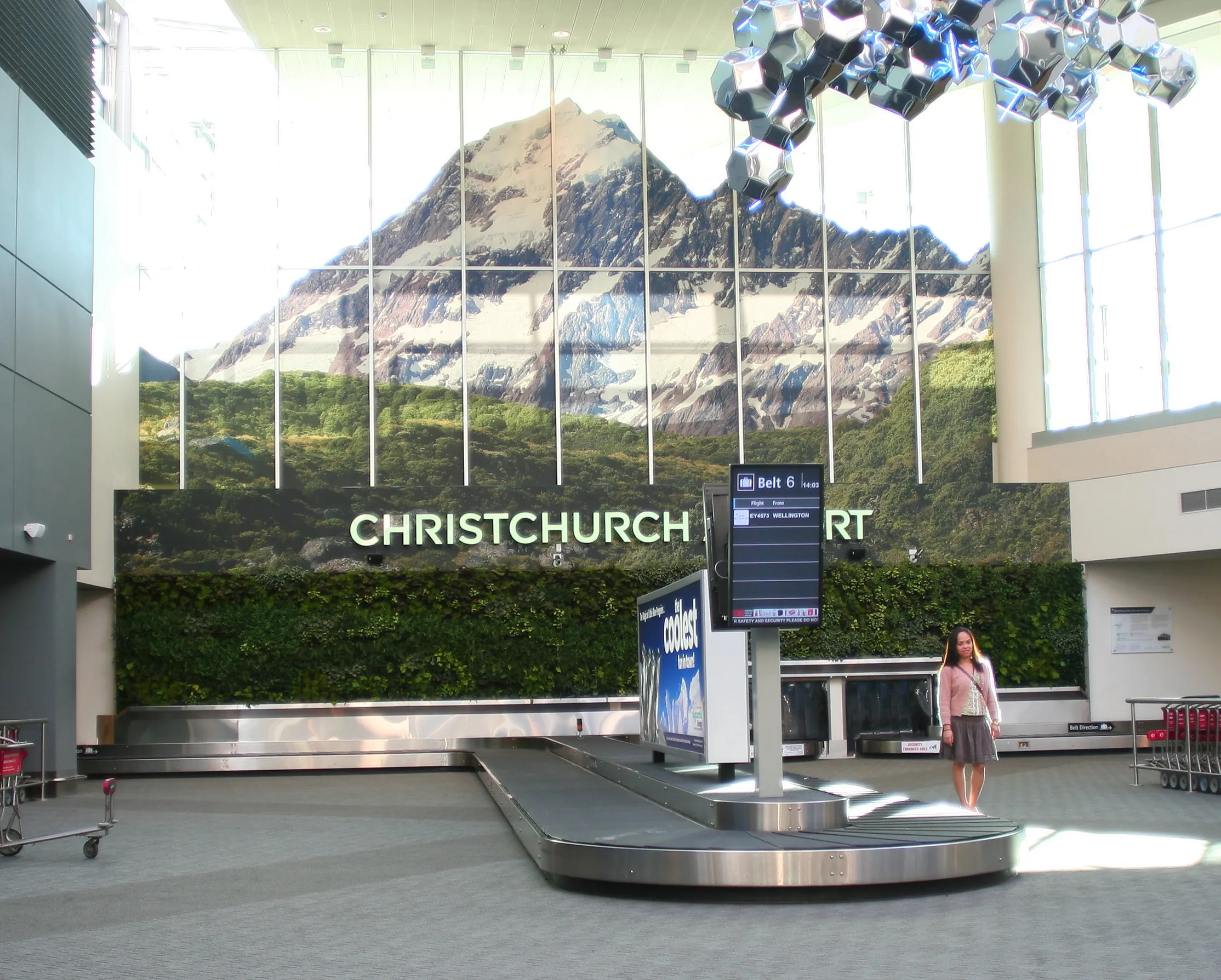 Christchurch Airport baggage claim with mountain landscape mural backdrop