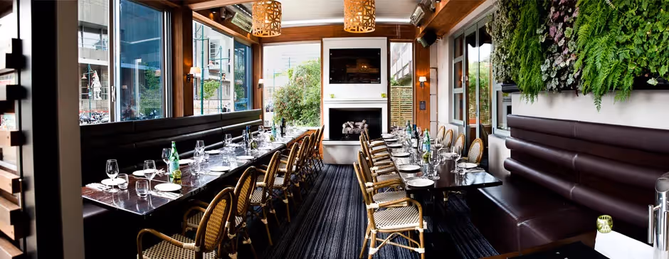 Elegant restaurant interior with wooden chairs, fireplace, and green wall decor