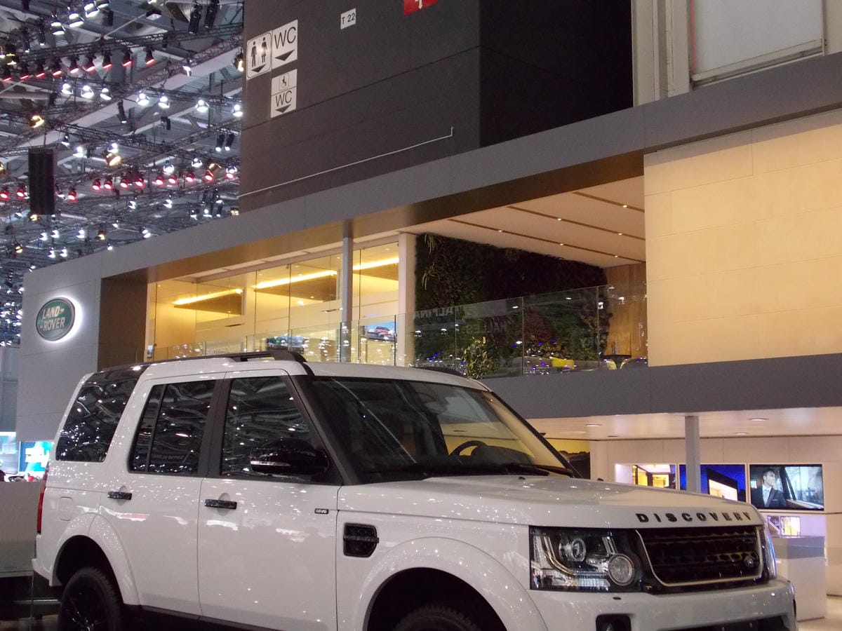 White Land Rover Discovery on display at a well-lit automotive show