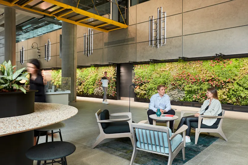 Living wall decorates modern office space with people relaxing and working