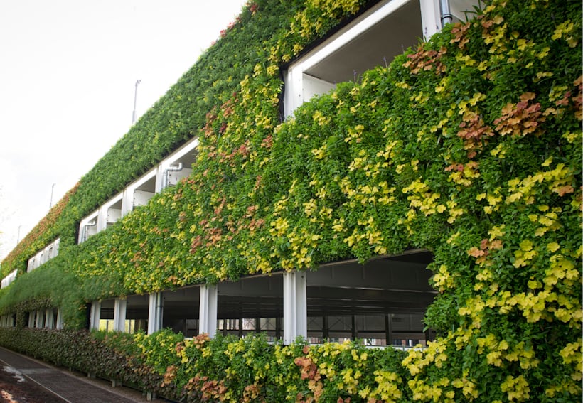 Living wall of green and yellow plants covering modern building facade of the National Rail car park