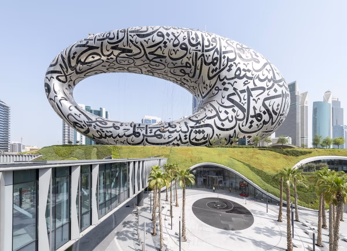 Full framed view of the museum of the future showing the silver curved structure covered in black patterns and Viritopia's living wall below it