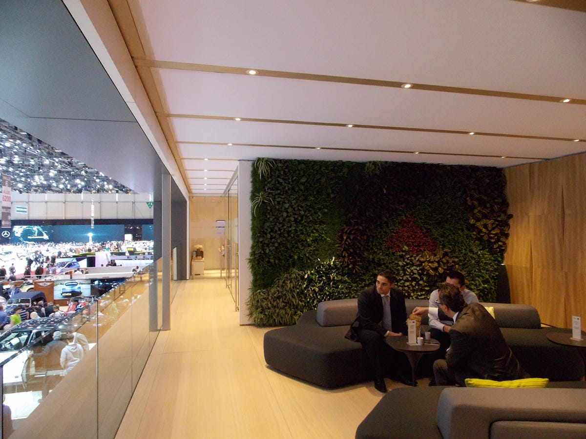 Two people sat on a sofa n front of an indoor living wall at the Geneva Motor Show