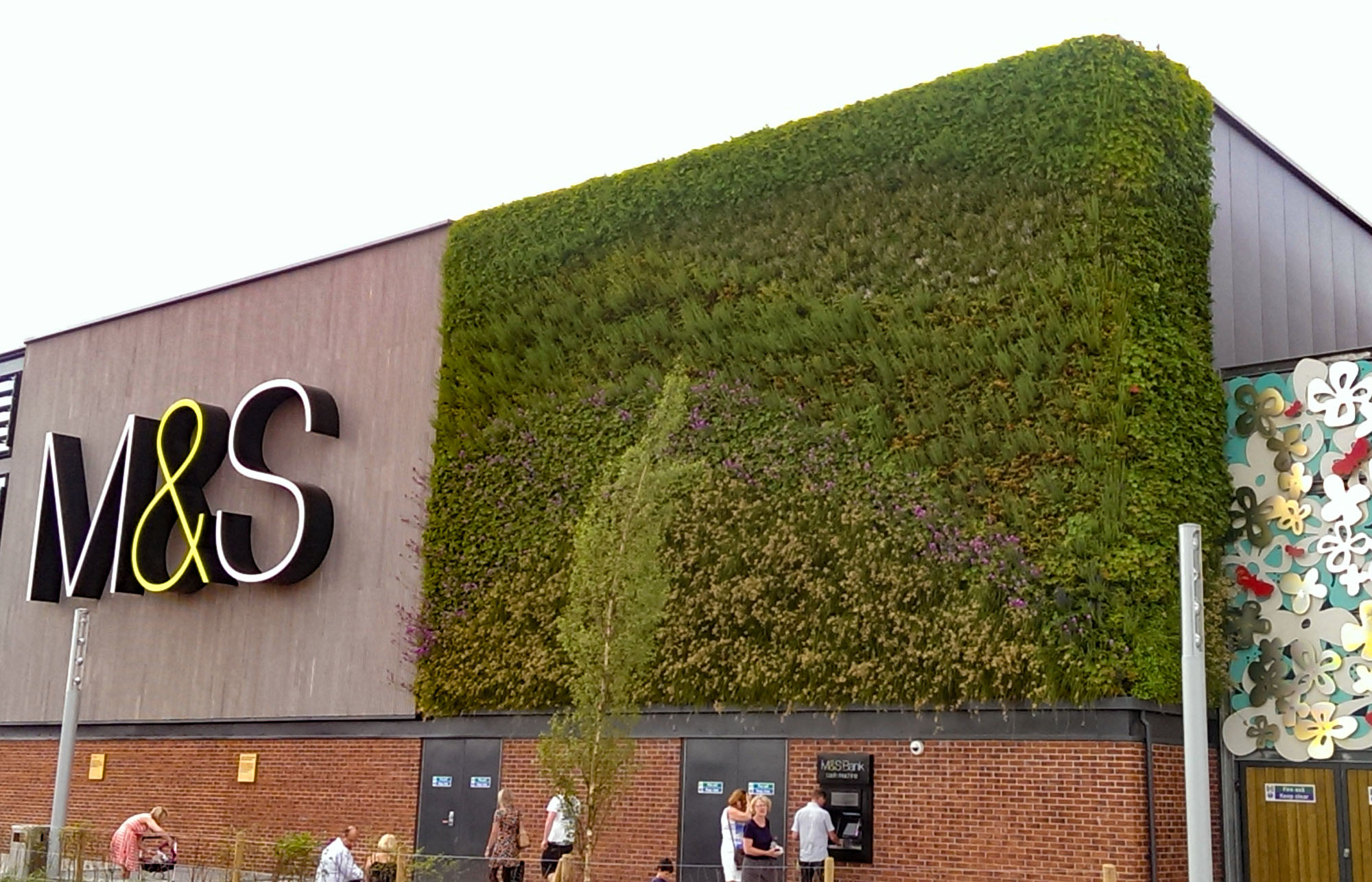 Front exterior of M&S Monks Cross, with a large living wall