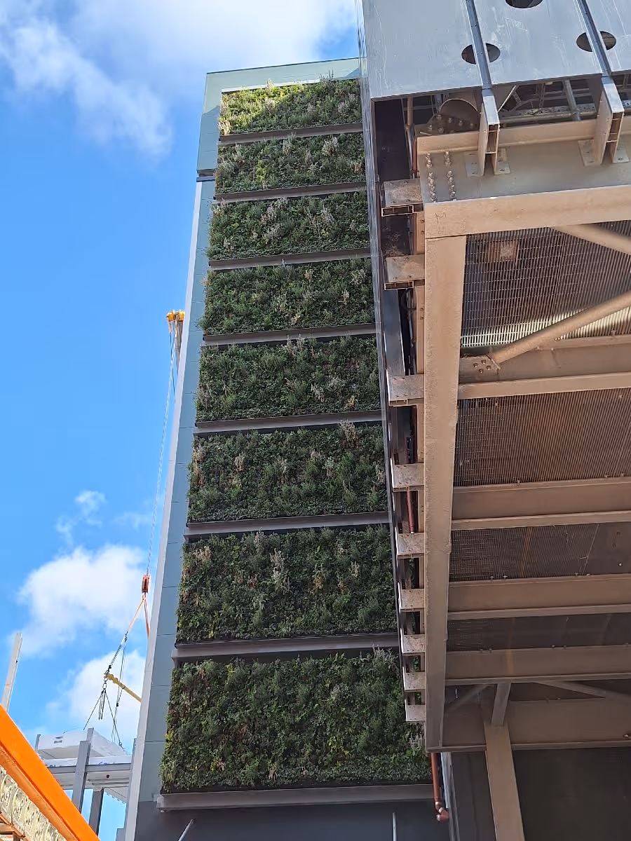 Viritopia modular living wall system being installed on a multi-storey data centre building, viewed from below, with construction crane visible