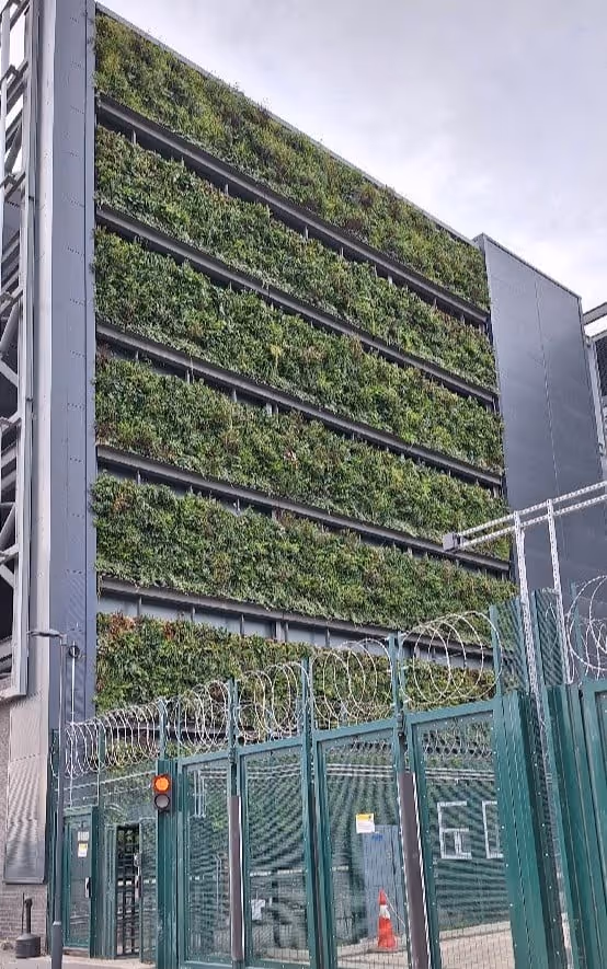 Viritopia modular living wall on a data centre building at Union Park, viewed from ground level behind a security perimeter fence