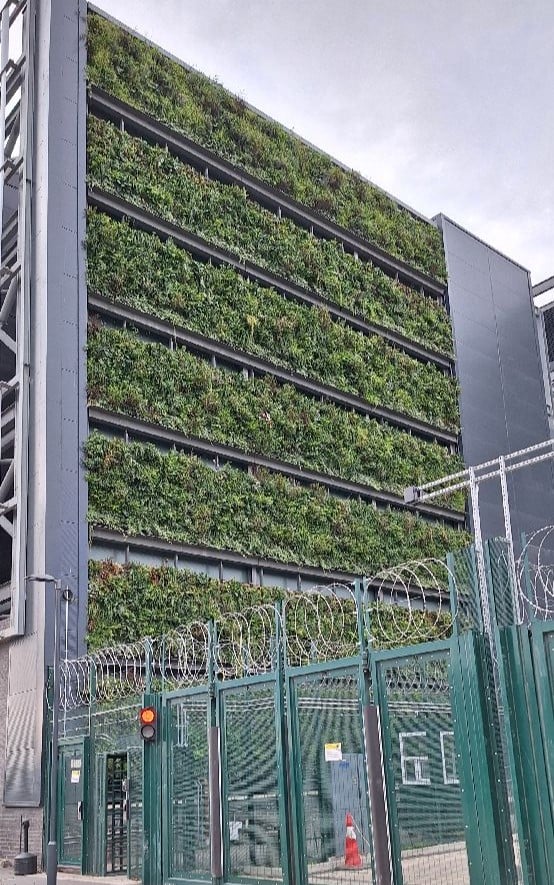 Viritopia modular living wall on a data centre building at Union Park, viewed from ground level behind a security perimeter fence