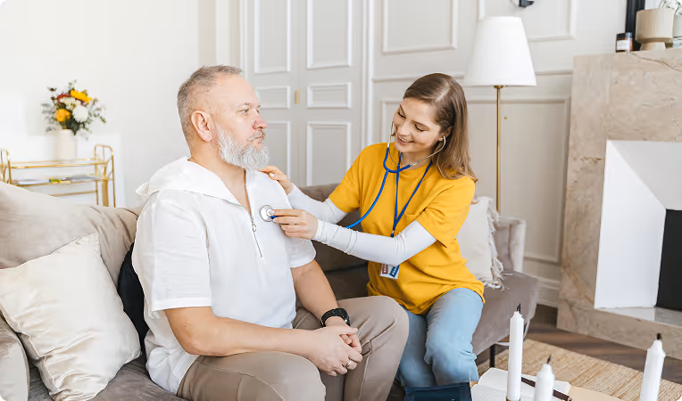 Woman helping elderly man with medication at home