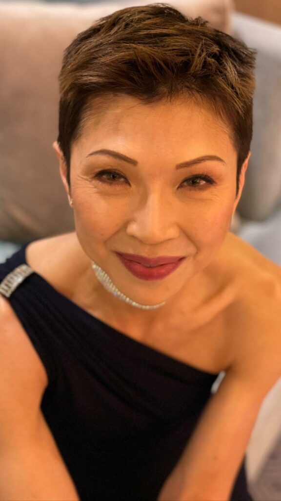 Close up of CC Kat sitting down in a black dress at awards ceremony