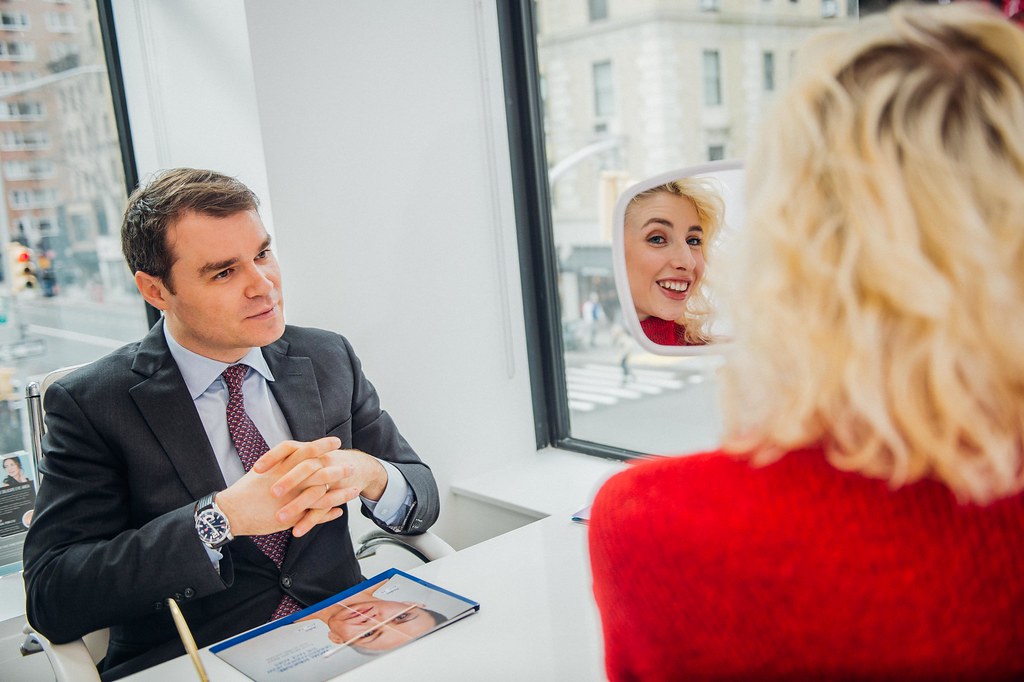 A clinician talks a patient through a cosmetic procedure during a consultation
