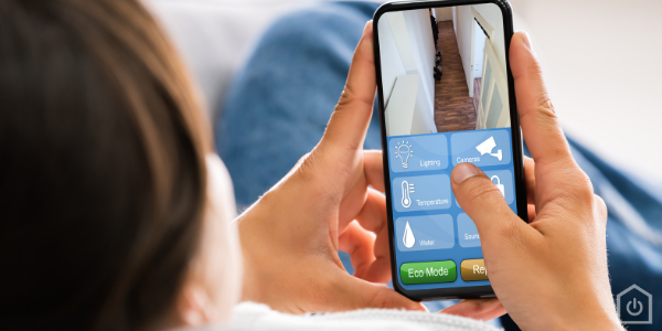 A person sitting on their phone looking at their security system.