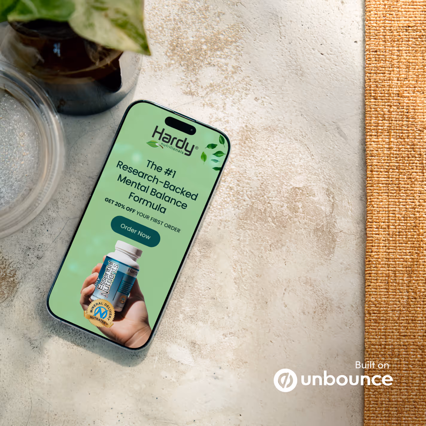 A smartphone displaying a mental balance formula ad lies on a textured surface next to a potted plant, creating a natural and calming scene.
