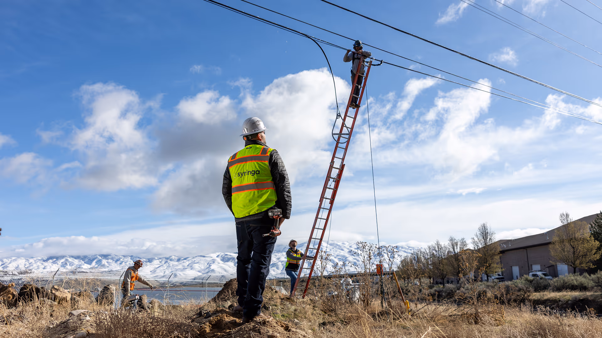 A laptop displaying an "About Us" page sits on a vibrant yellow and purple perforated surface, conveying a modern and innovative tone.