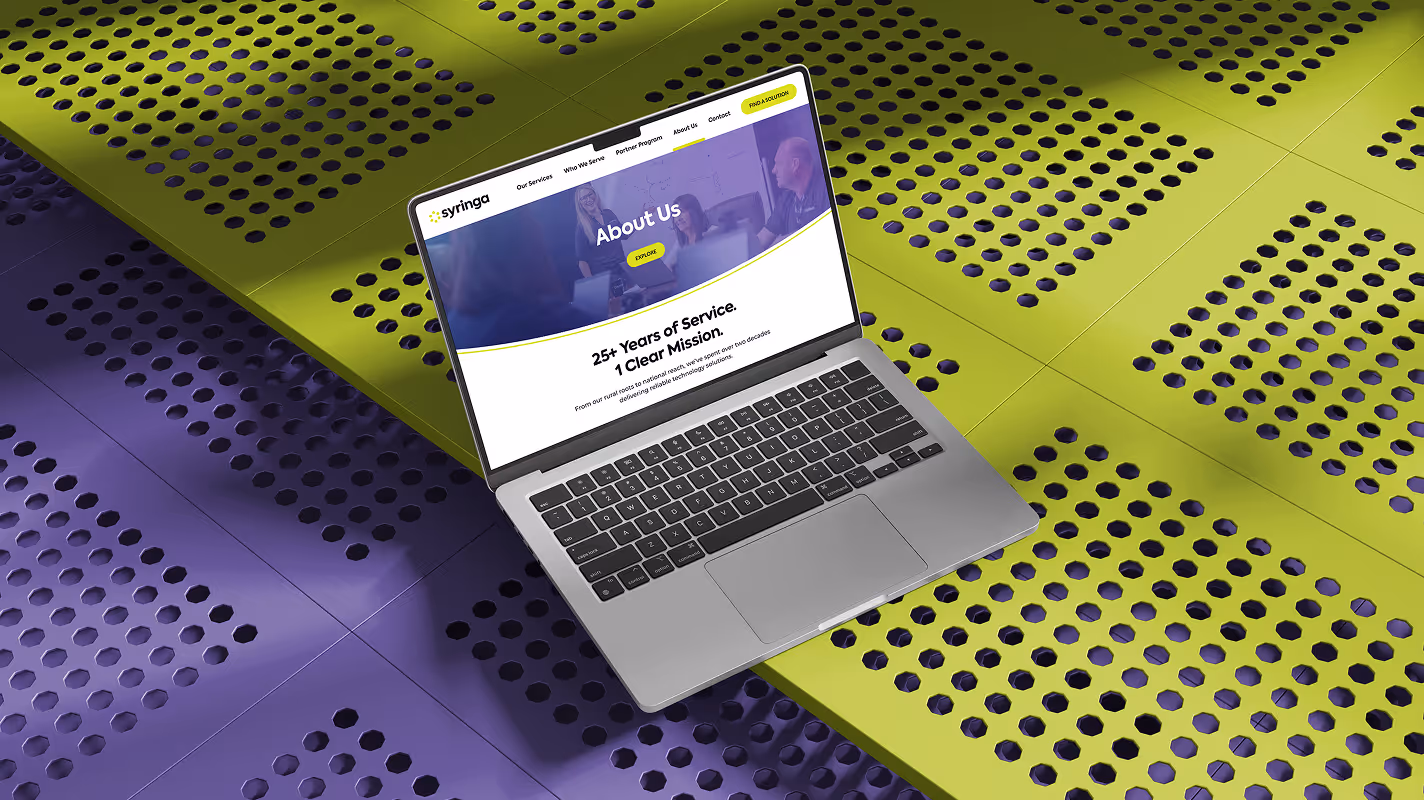 A laptop displaying an "About Us" page sits on a vibrant yellow and purple perforated surface, conveying a modern and innovative tone.