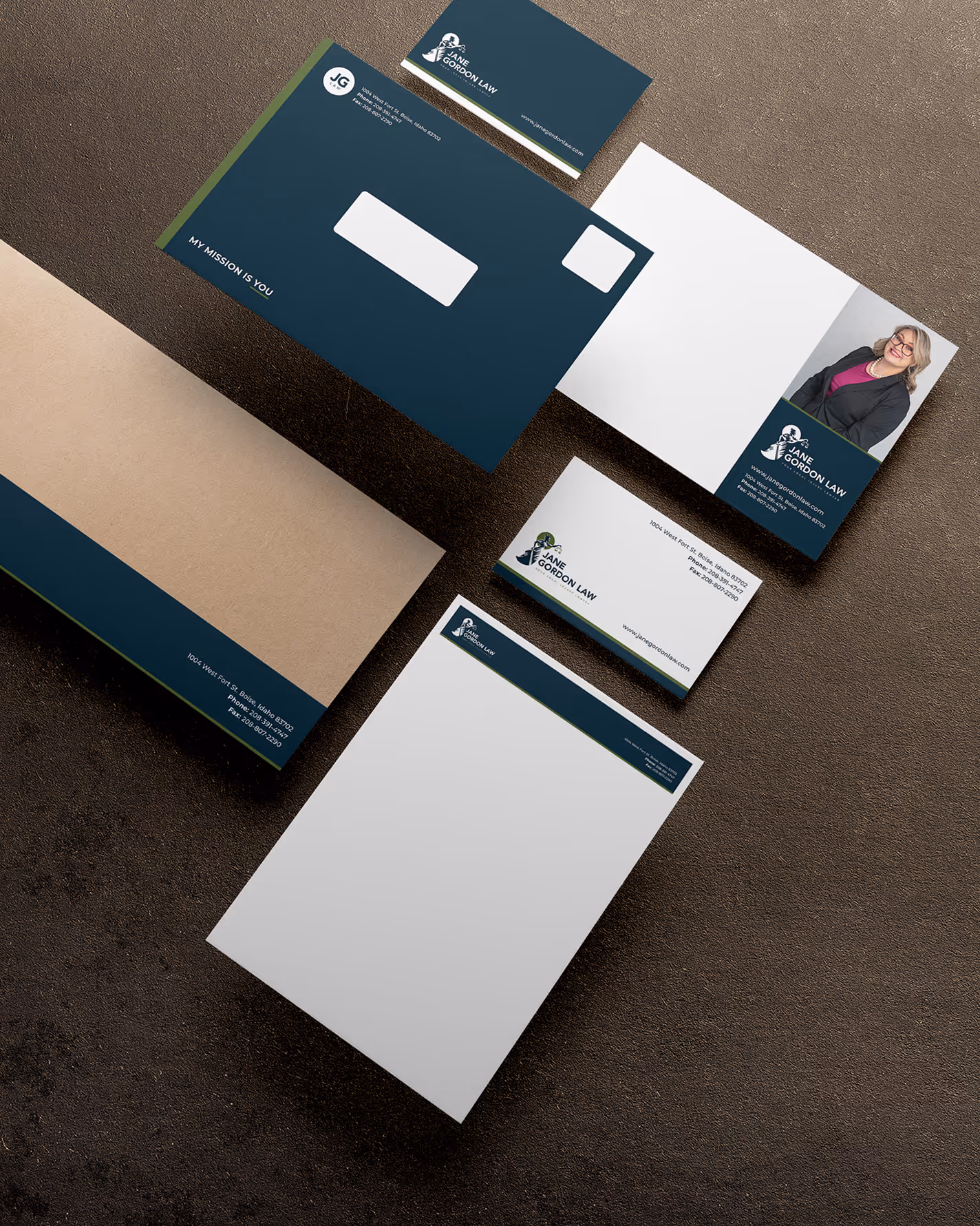 A flat lay of professional stationery on a dark surface features a navy blue and white theme. Items include envelopes, business cards, and letterheads.