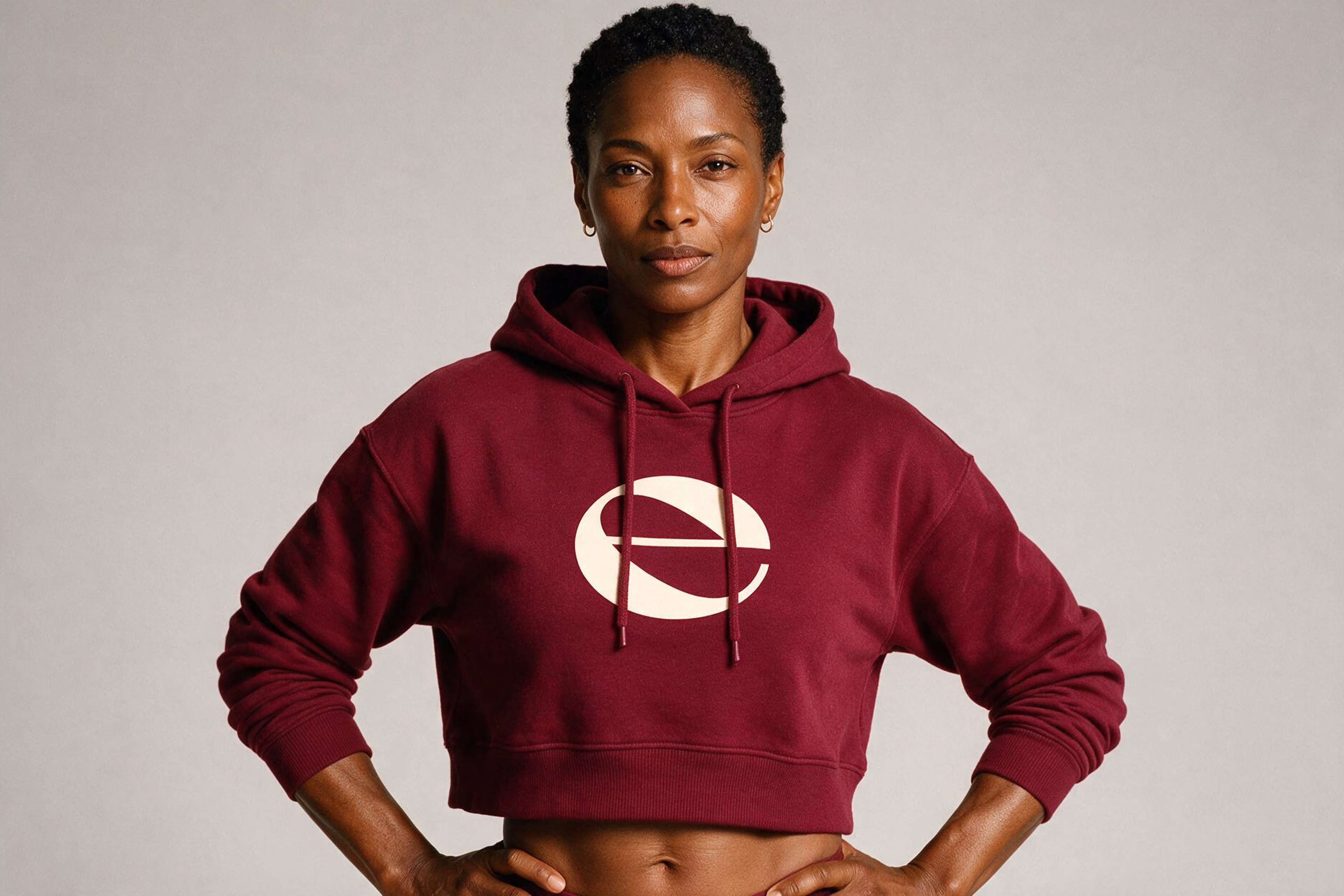 Woman wearing a burgundy hoodie with the EllaNu e emblem.