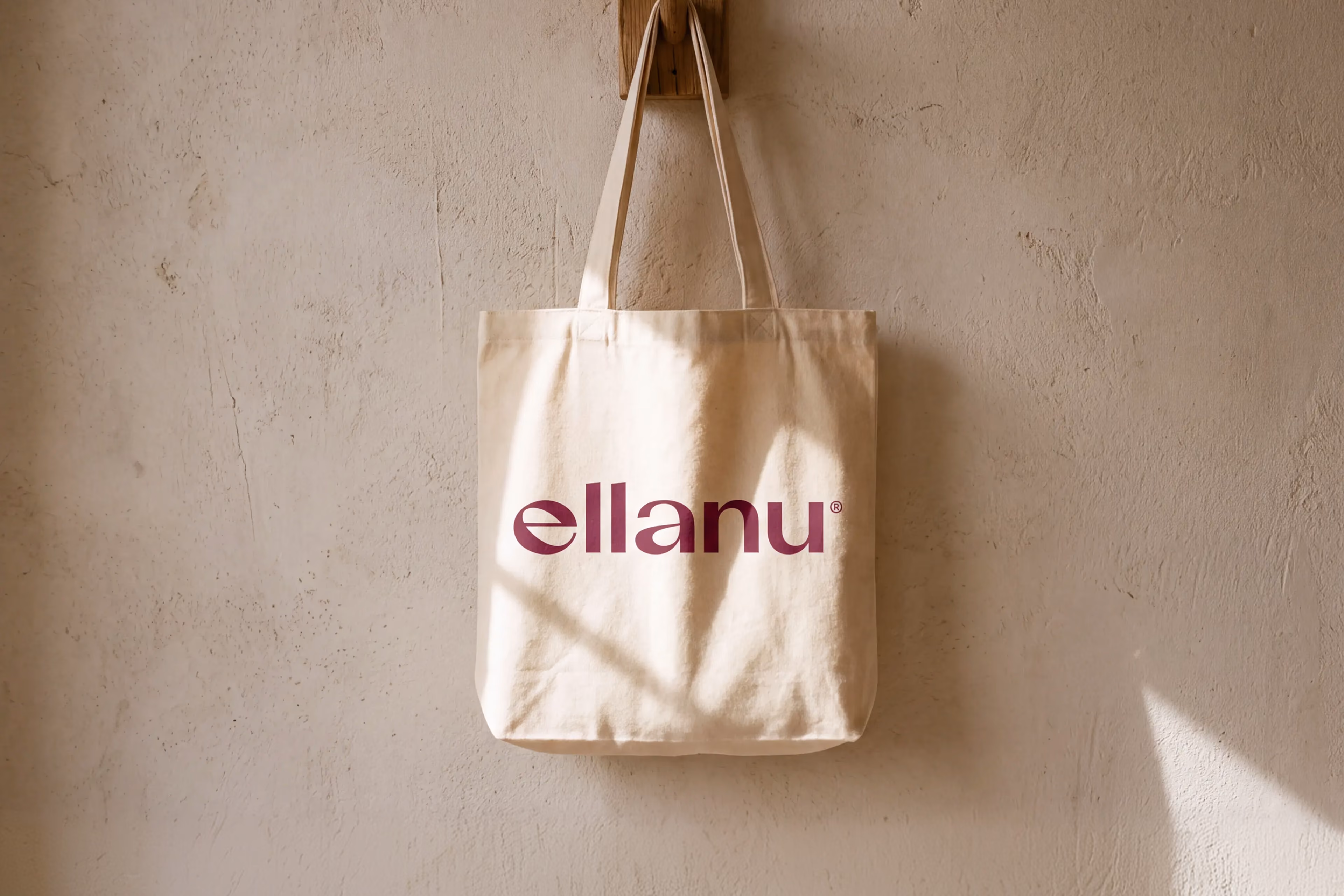 Cream tote bag printed with the burgundy EllaNu wordmark.