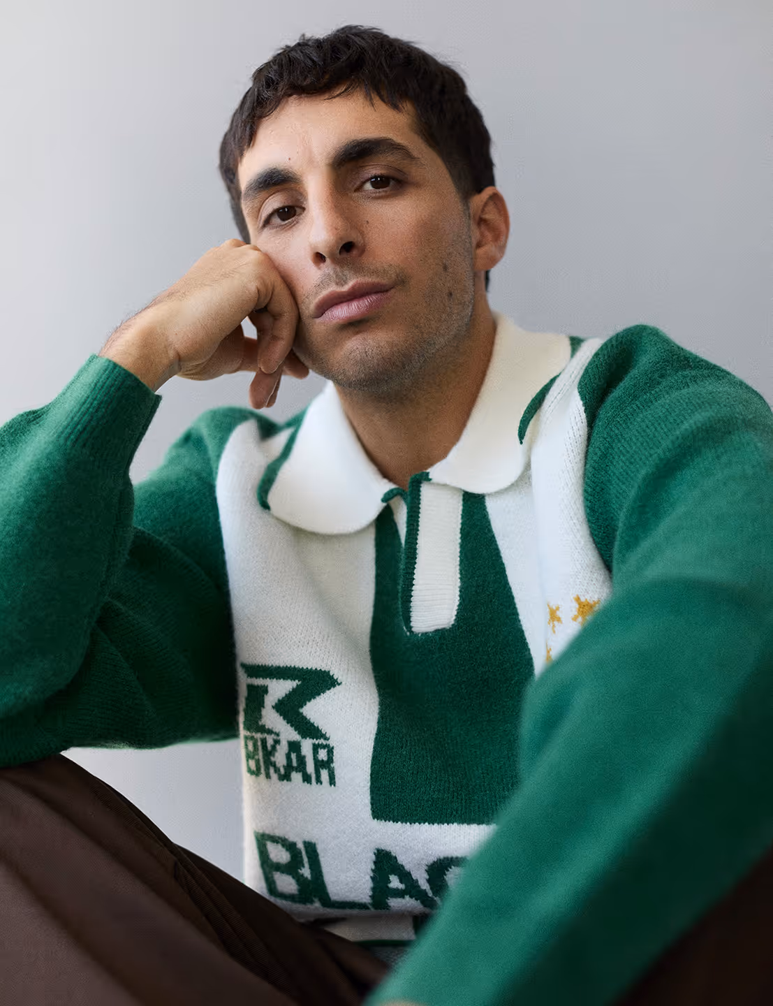 Mike Clay est un chanteur séduisant avec un polo vert qui regarde la caméra parce qu'on le prend en photo.