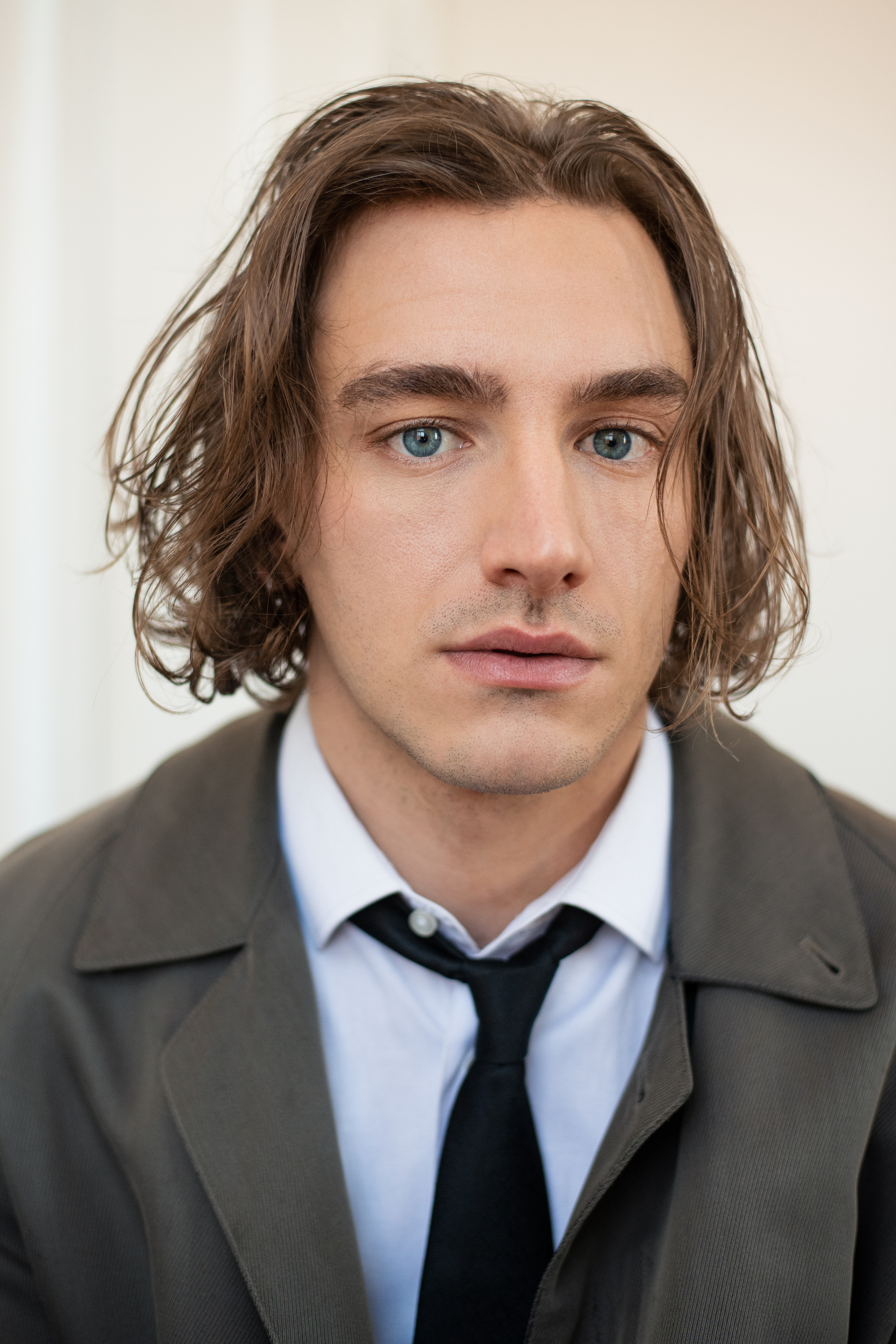 Xavier Bergeron est un acteur blond avec les cheveux longs et une cravate noire. 