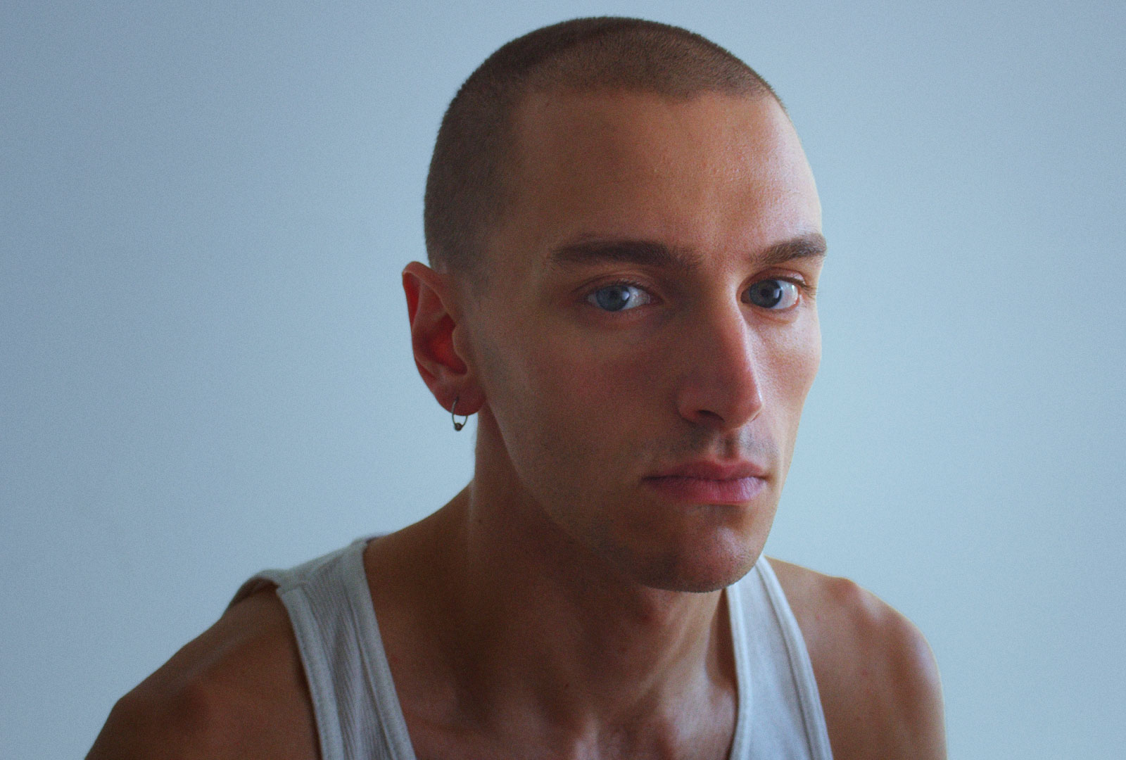 Xavier Bergeron est un comédien de la relève avec le crâne rasé, les yeux bleus et une camisole blanche.