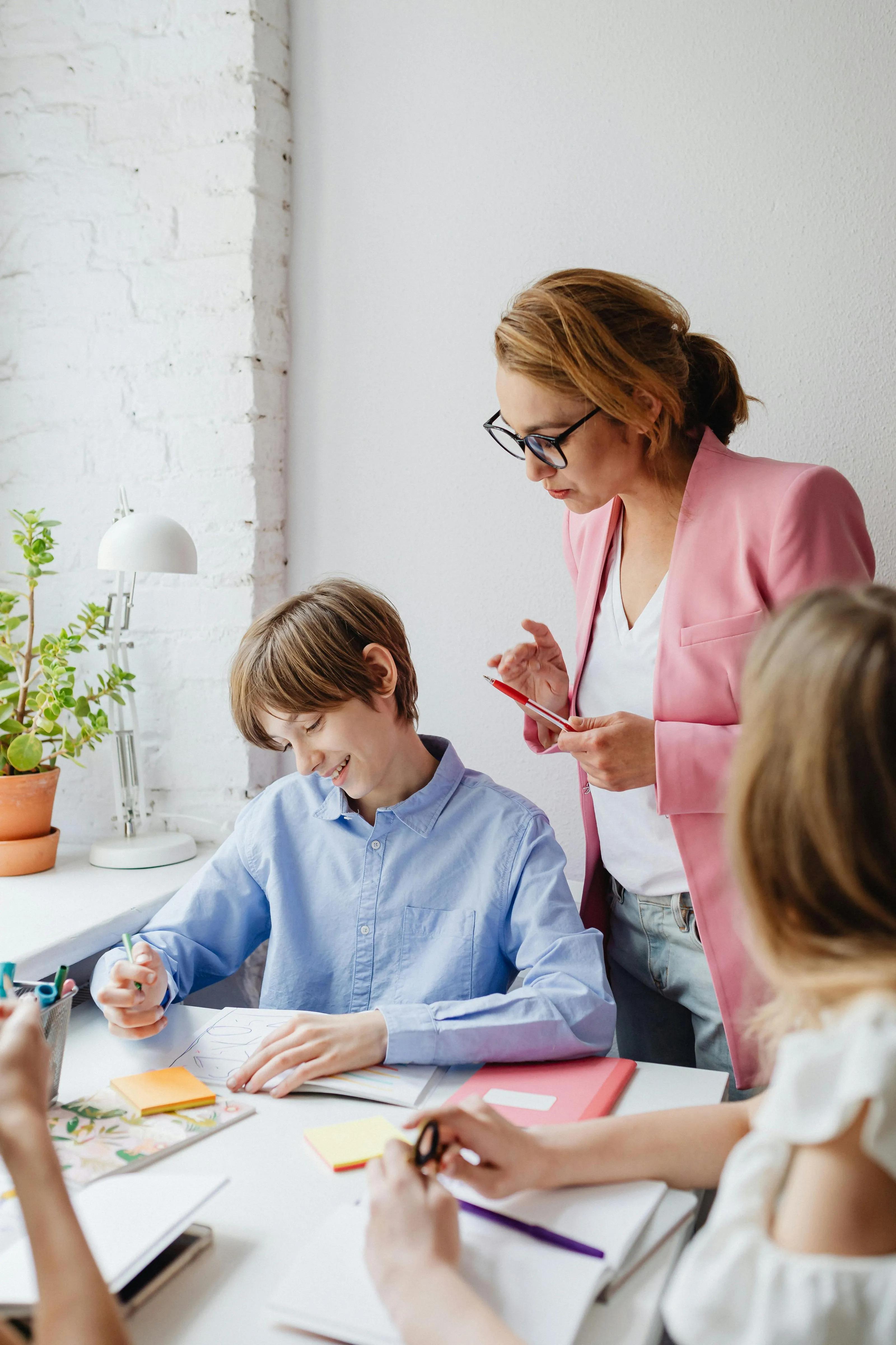 A teacher is watching her students, observing them with a calm and attentive expression