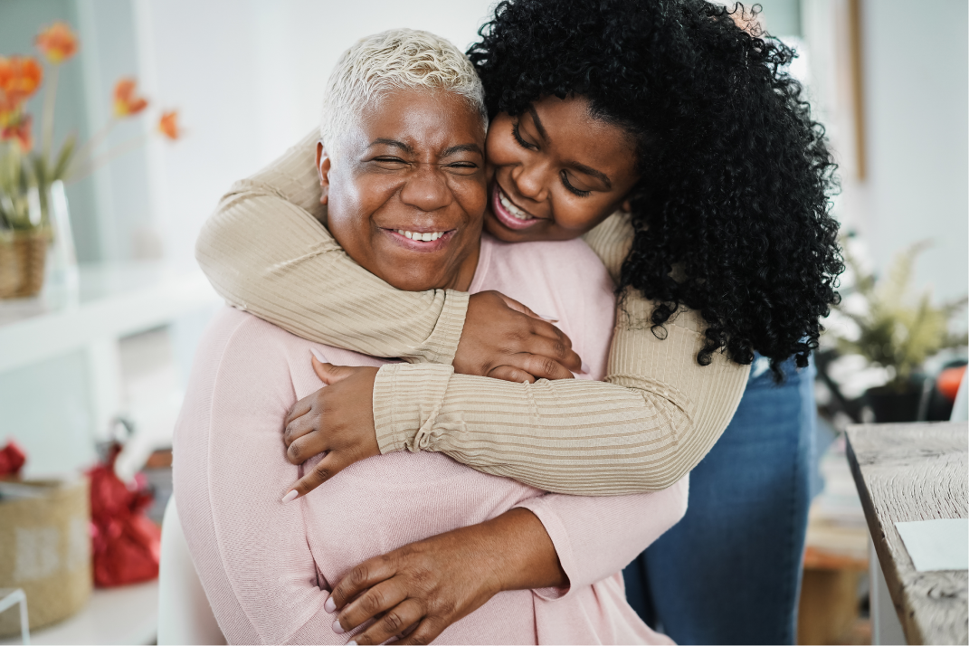A young woman embraces her older relative