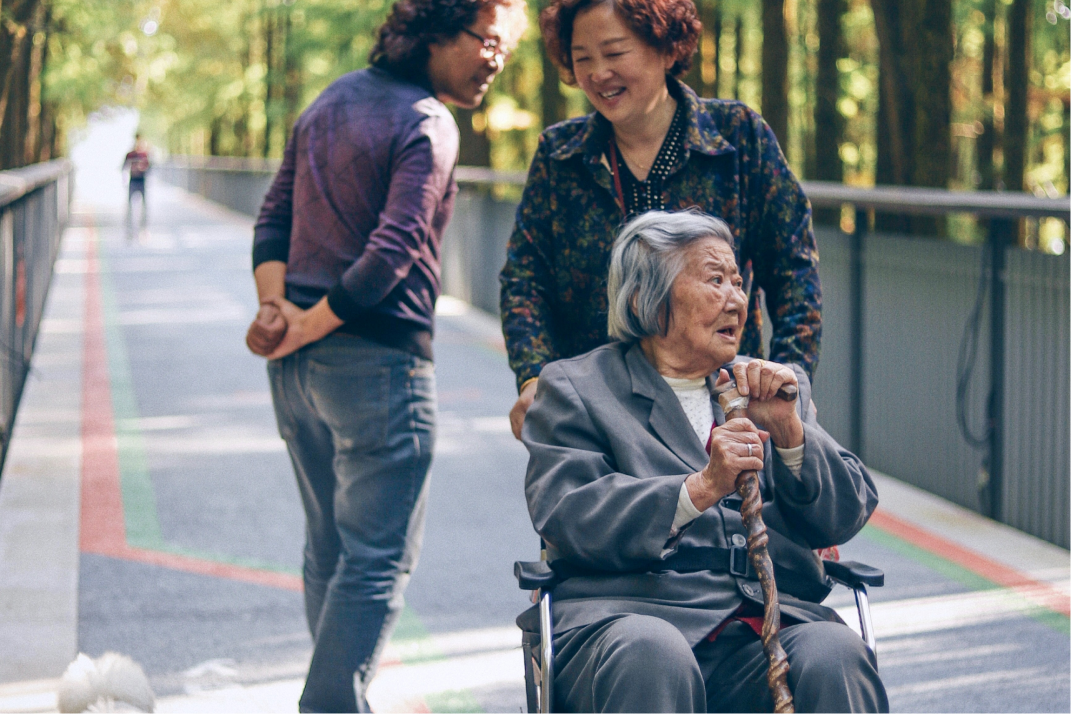 An older woman in a wheelchair with younger relatives