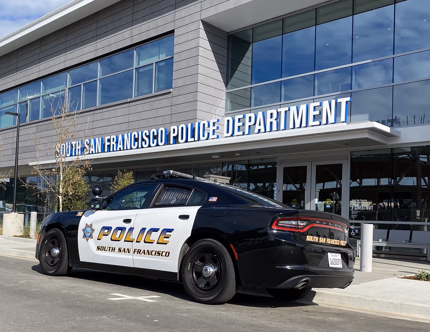 Black and white South San Francisco police car parked in front of the South San Francisco Police Department building.
