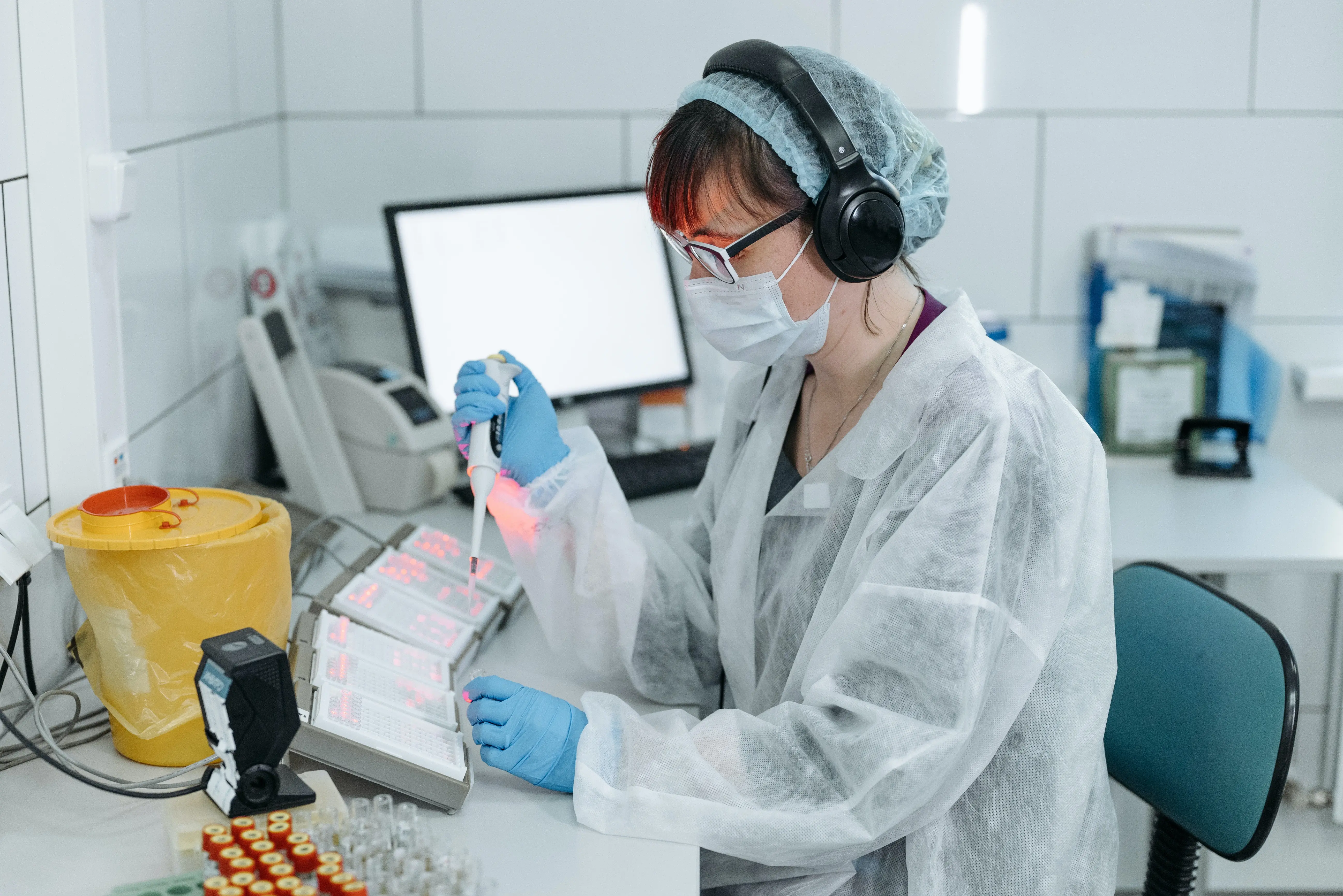 Scientist pipetting samples at a lab bench in a biotech startup.