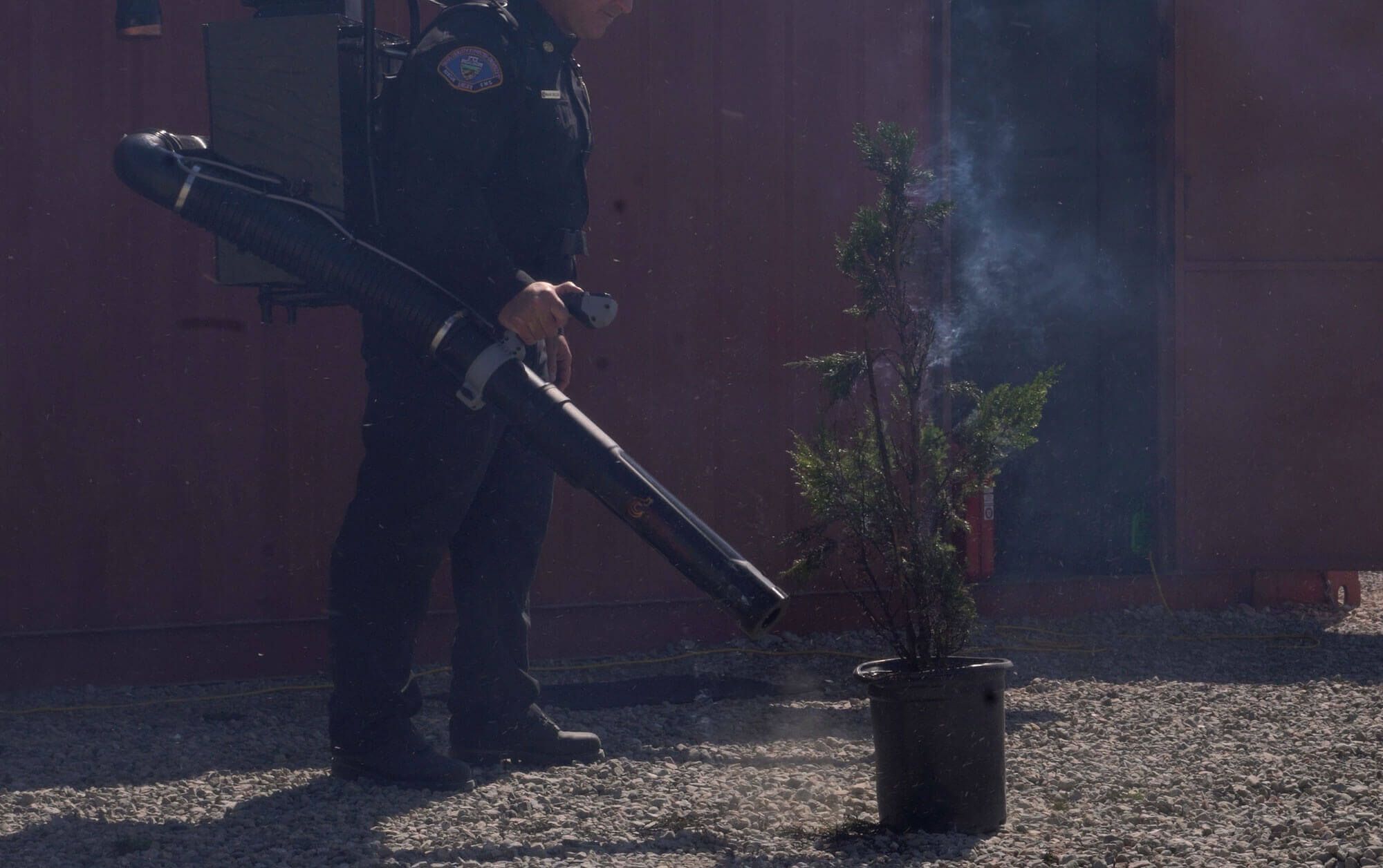First Responder using Sonic Fire Backpack to extinguish flame.