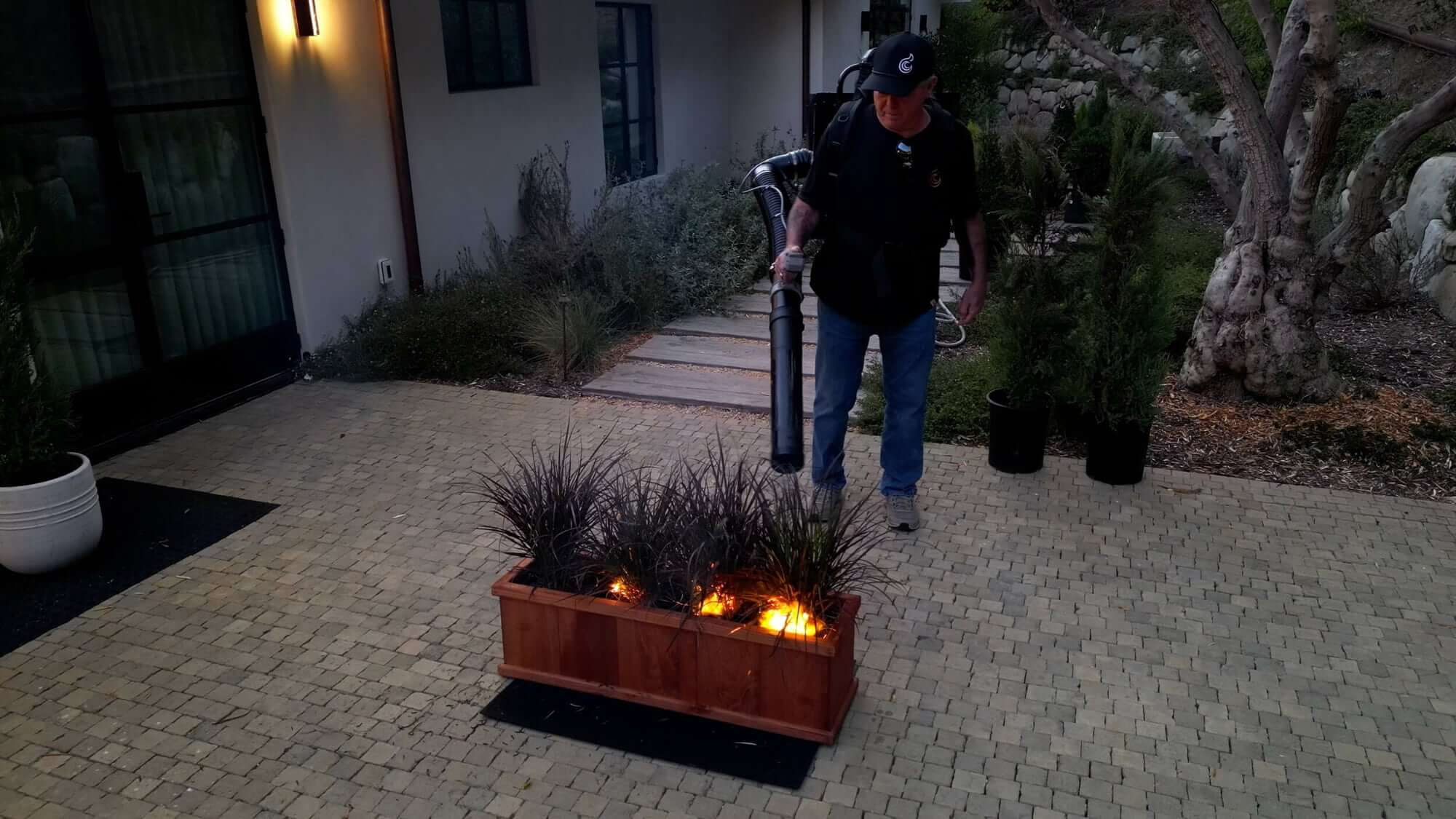 A person using the Sonic Fire Tech backpack unit demonstrates putting out a brush fire.