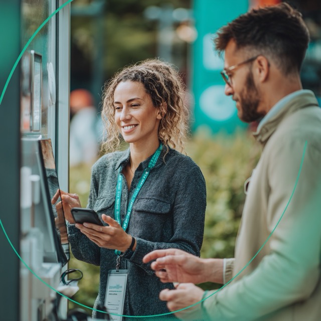 Sales person helping a client in front of a telecom kiosk