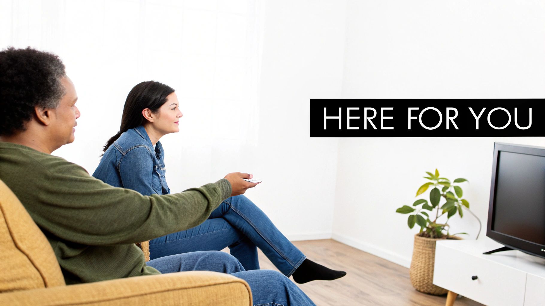 A supportive hand rests on the shoulder of a person looking out a window, signifying comfort and presence during a difficult time.