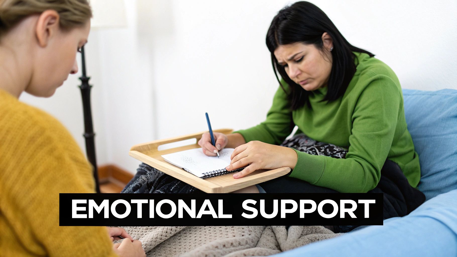 A woman sits comfortably on her couch, holding a journal and pen.