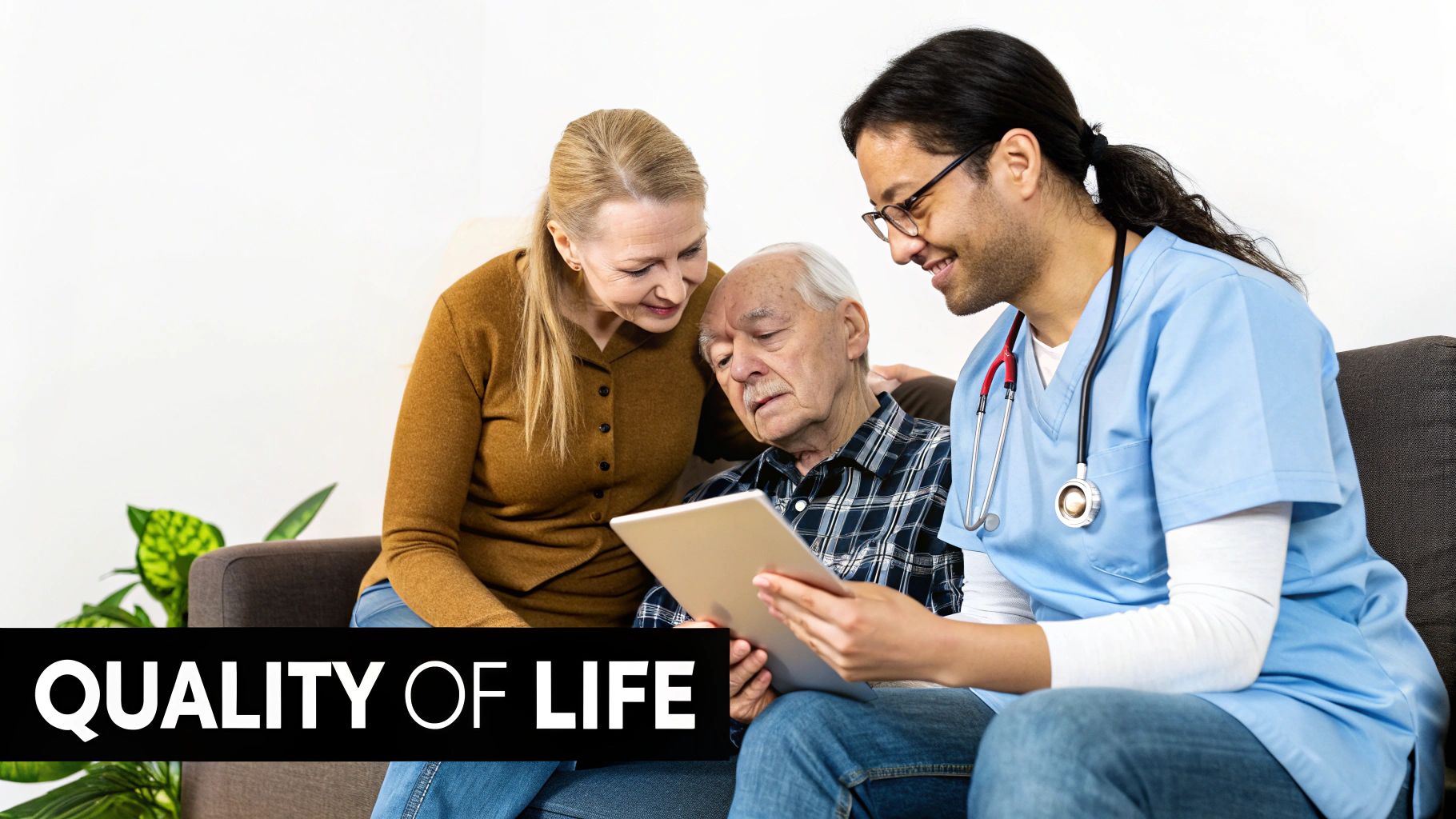 A caregiver, a woman, and an elderly man happily view a tablet together, emphasizing quality of life.