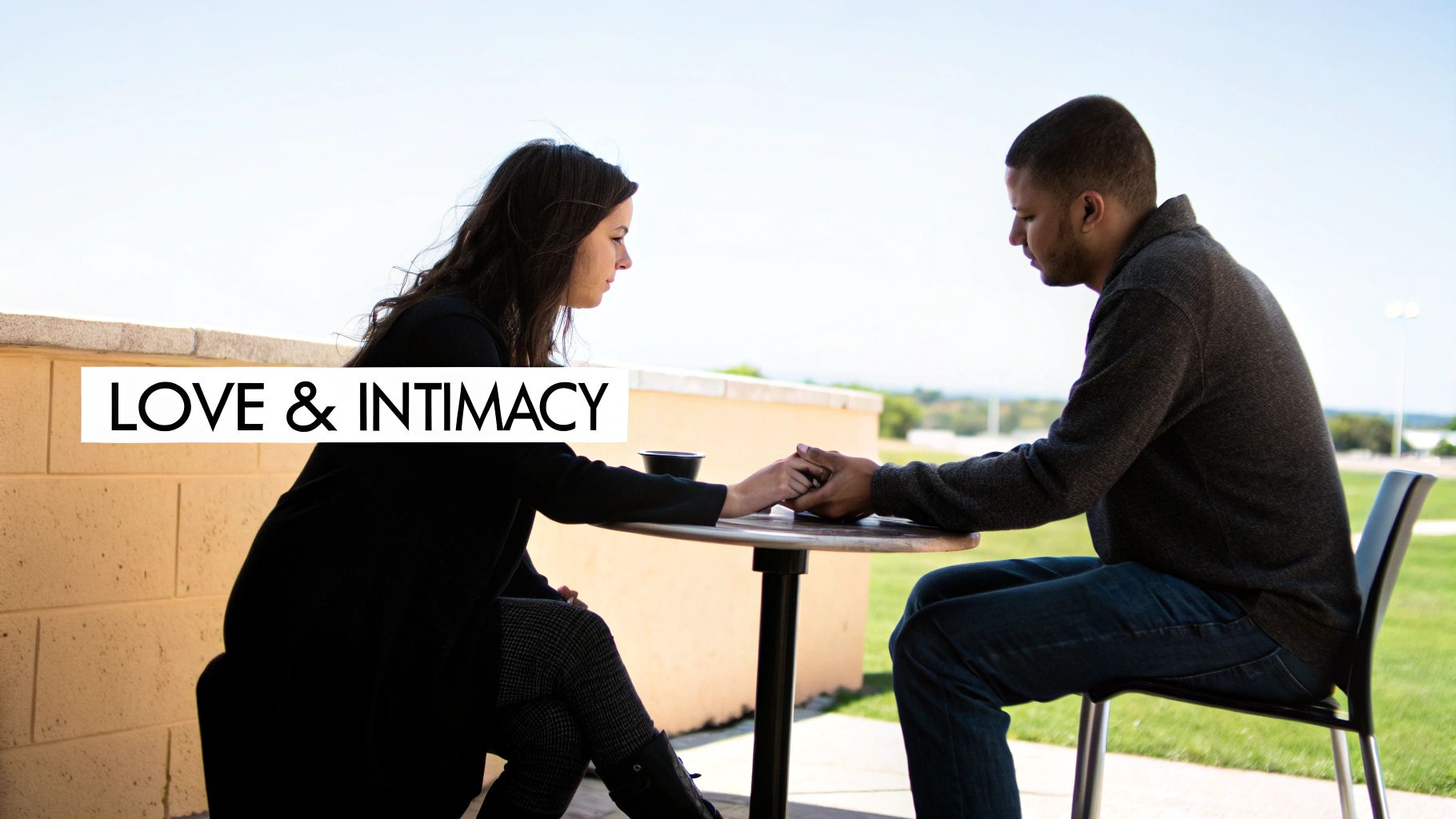 A couple sits at an outdoor table, holding hands, with "LOVE & INTIMACY" text overlay, symbolizing connection.