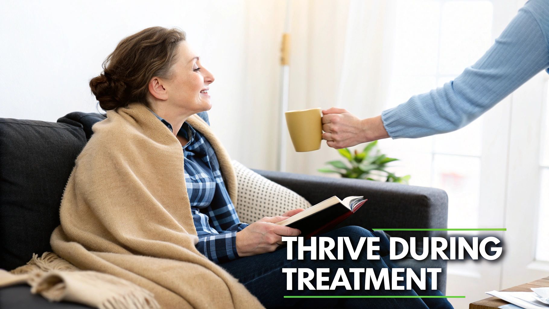 A smiling woman under a blanket on a couch receives a warm mug, reading a book.