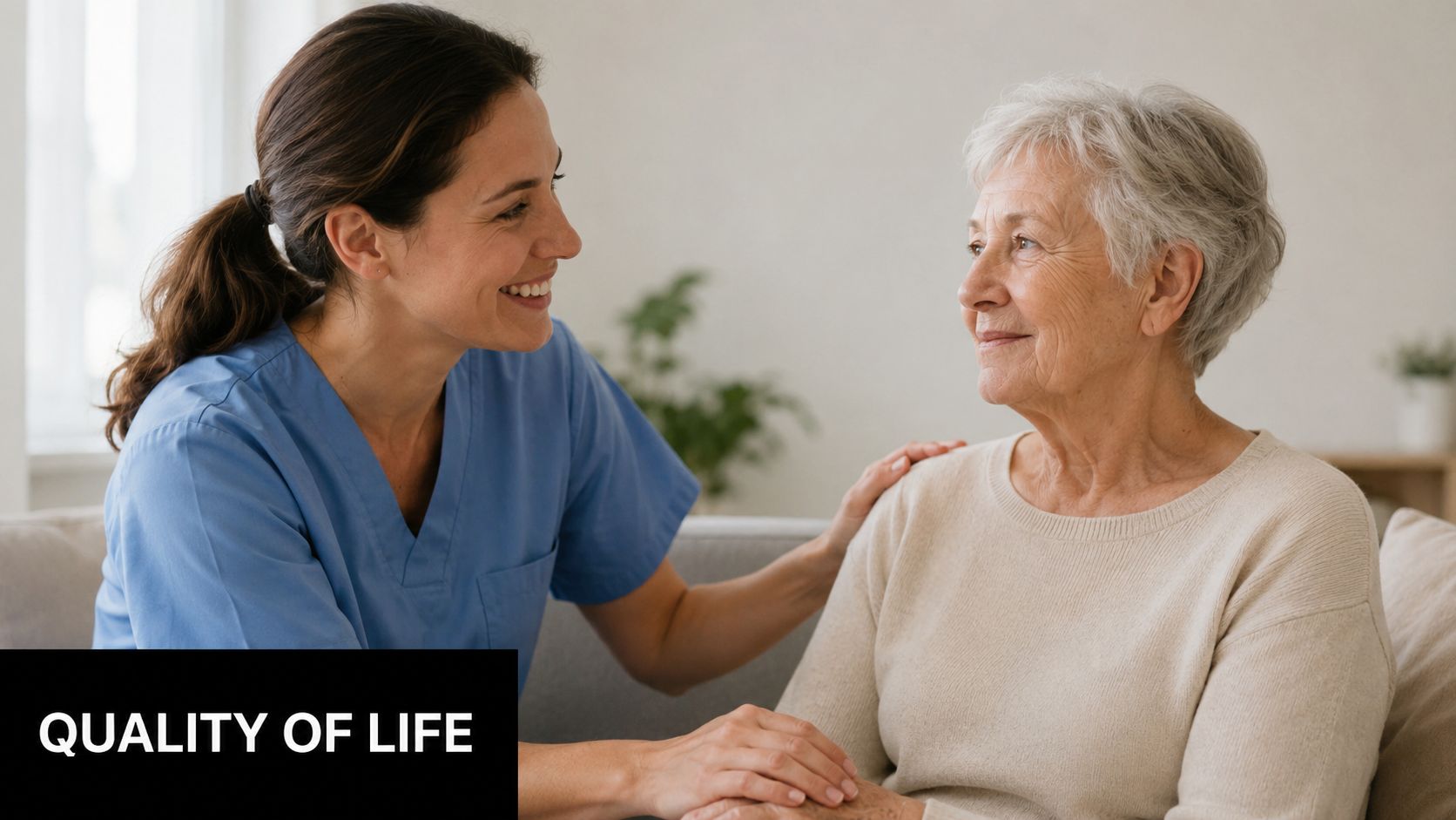 A friendly caregiver smiling while comforting and holding the hand of an elderly woman at home.